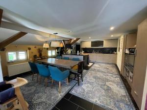 a kitchen with a wooden table and blue chairs at Loftartiges Wohnen mit 4 separaten Schlafbereichen in Au in der Hallertau