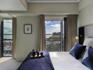 ein Hotelzimmer mit einem Bett und einem großen Fenster in der Unterkunft The Sebel Auckland Viaduct Harbour in Auckland + 21 Fotos