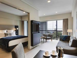 a hotel room with a bed and a living room at The Sebel Auckland Viaduct Harbour in Auckland +27 photos