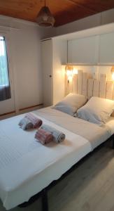 a large white bed with two towels on it at Chalet à la campagne chez Sabine in Saint-Beauzire