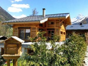 a wooden house with a mountain in the background at Apartment Chalet Fouladoux in Les Houches