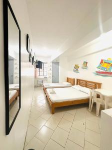 a bedroom with two beds and a mirror at Frank Lloyd Apartelle in Manila +78 photos