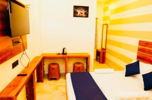 a bedroom with a desk and a bed and a desk at Aps inn munnar in Munnar +11 photos