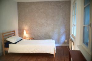 a bedroom with a white bed and a window at Chambre privée pour routard dans un appartement partagé in Strasbourg