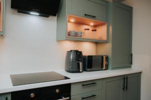 cocina con microondas y cafetera en una encimera en Spacious Flat with Parking Great Inverness Base, en Inverness 20 fotos más