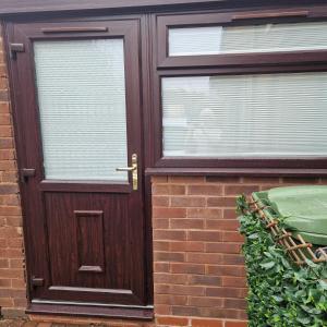 a wooden door on the side of a brick house at Welcoming ensuite bedroom in Wolverhampton +3 photos