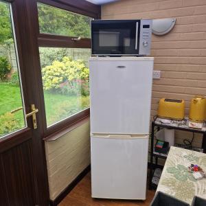 a microwave sitting on top of a refrigerator at Welcoming ensuite bedroom in Wolverhampton