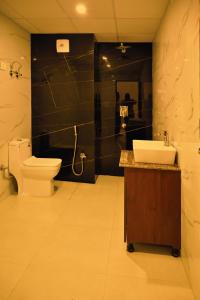 a bathroom with a toilet and a sink at The Opal Hotel in Greater Noida