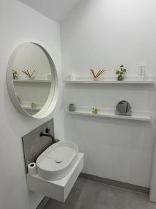 a white bathroom with a sink and a mirror at Contemporary modern barn in Folkestone