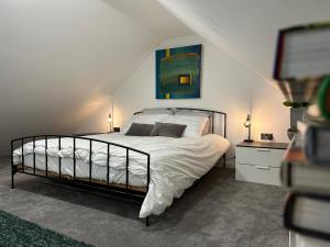 a bedroom with a bed and a painting on the wall at Contemporary modern barn in Folkestone