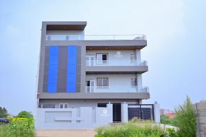 a tall white building with blue squares on it at The Opal Hotel in Greater Noida