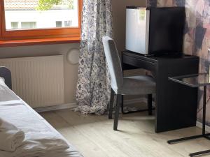 a bedroom with a desk with a tv and a chair at Lodge in Wrocław