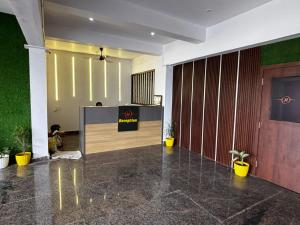 an office lobby with a reception desk and plants at The Opal Hotel in Greater Noida +21 photos