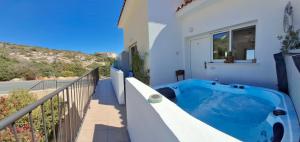 a hot tub on the balcony of a house at ATLANTIS Penthouse Apartment with Jacuzzi plus Pool and Sea Views in Peyia