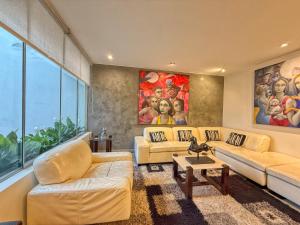 a living room with two couches and a painting at Beautiful Penthouse in Lima, in front of the park in Lima