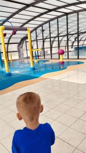 a young boy standing in front of a swimming pool at Mobil home ch ti in Litteau