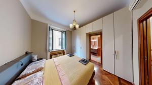 een slaapkamer met een bed en een groot raam bij Wonderful downtown apartment-HD NETFLIX, KING-SIZE BED, two minutes' walk from metro in Milaan