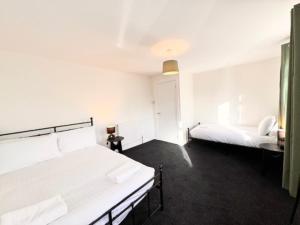 a white room with two beds in it at Entire New 4 Bed House Southampton 10 Guests in Southampton