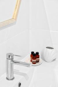 a bathroom sink with two jars of honey on it at Sandy Toes & Salty Kisses in Apollo Bay