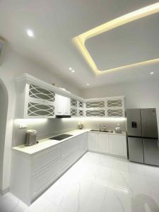 a large kitchen with white cabinets and a refrigerator at Classic homestay in Thôn Trường Giang