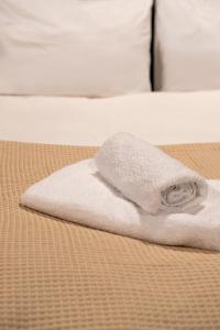 a white towel sitting on top of a bed at House of Paralympic Athlete Mike Seitis in Rhodes Town