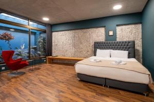 a bedroom with a large bed and a red chair at House of Paralympic Athlete Mike Seitis in Rhodes Town