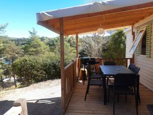 Un patio con una mesa y sillas en una terraza. en Mobil home des gorges de provence, en Montagnac