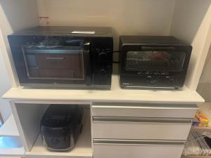 a microwave and a toaster oven in a kitchen at Otsu guest house2 in Chikusei