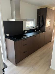 a kitchen with a sink and a counter top at Luxe vakantiewoning Hellendoorn Sallandse Heuvelrug nmr 36 in Haarle +11 photos