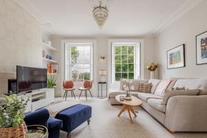 a living room with a couch and a tv at Stylish 5-Bed Townhouse in Prime Leamington Spa in Leamington Spa