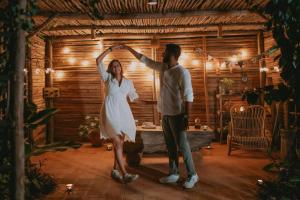 a man and a woman dancing in a room at The Mudhouse Marayoor in Munnar