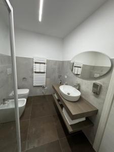 a bathroom with a sink and a mirror and a toilet at Moro Luxury Rooms in Grassobbio
