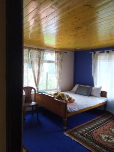 a bedroom with a bed with a window and a chair at The Garden View Family Homestay in Takdāh