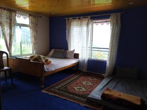 a bedroom with a bed with a dog sleeping on it at The Garden View Family Homestay in Takdāh +3 photos