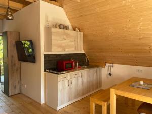 a kitchen with a red microwave and a table at Müllers Ferienhäuser Gunaras & Harmonie in Gunaras in Dombóvár