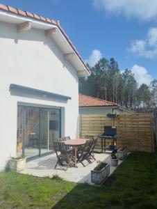 a patio with a table and chairs and a grill at La villa du point du jour in Lit-et-Mixe +4 photos