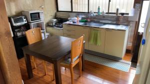a kitchen with a wooden table and a sink at Iioka-classic in Asahi