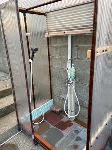 a shower in a building with a hose at Iioka-classic in Asahi +6 photos