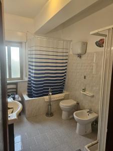 a bathroom with a tub and a toilet and a sink at Villa Butterfly in Santa Domenica