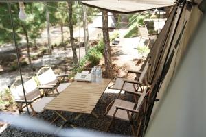 a porch with a table and chairs and an umbrella at Finest Camp in Cibogo