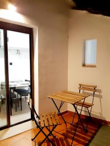 mesa y sillas en una habitación con mesa y ventana en La Rúa 4, en Úbeda