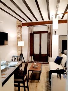 una sala de estar con una mesa y un sofá en La Rúa 4, en Úbeda