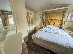 a bedroom with a bed with a wooden head board at 6 Berth Caravan For Hire At California Cliffs In Scratby By The Beach Ref 50050L in Great Yarmouth