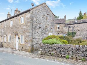 een oud stenen huis aan de straatkant bij Victoria Cottage in Kettlewell