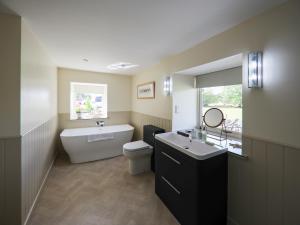 a bathroom with a toilet and a sink and a tub at The Wheelhouse in Kirk Yetholm +2 photos