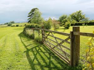 ein Holzzaun mitten auf einem Feld in der Unterkunft The Cottage in South Barrow