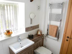 ein Badezimmer mit Waschbecken, Toilette und Spiegel in der Unterkunft The Cottage in South Barrow