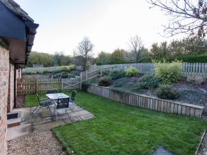 a patio with a table and chairs in a yard at Ash Barn - Fernhill Farm in Ryde