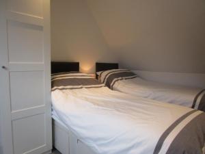 a row of three beds in a room at Ash Barn - Fernhill Farm in Ryde +10 photos