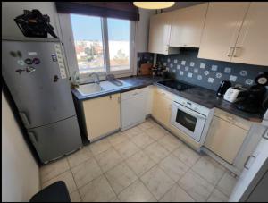 a kitchen with a refrigerator and a sink at T2 top floor with balcony - Stadium-Arena-Eurexpo in Décines-Charpieu